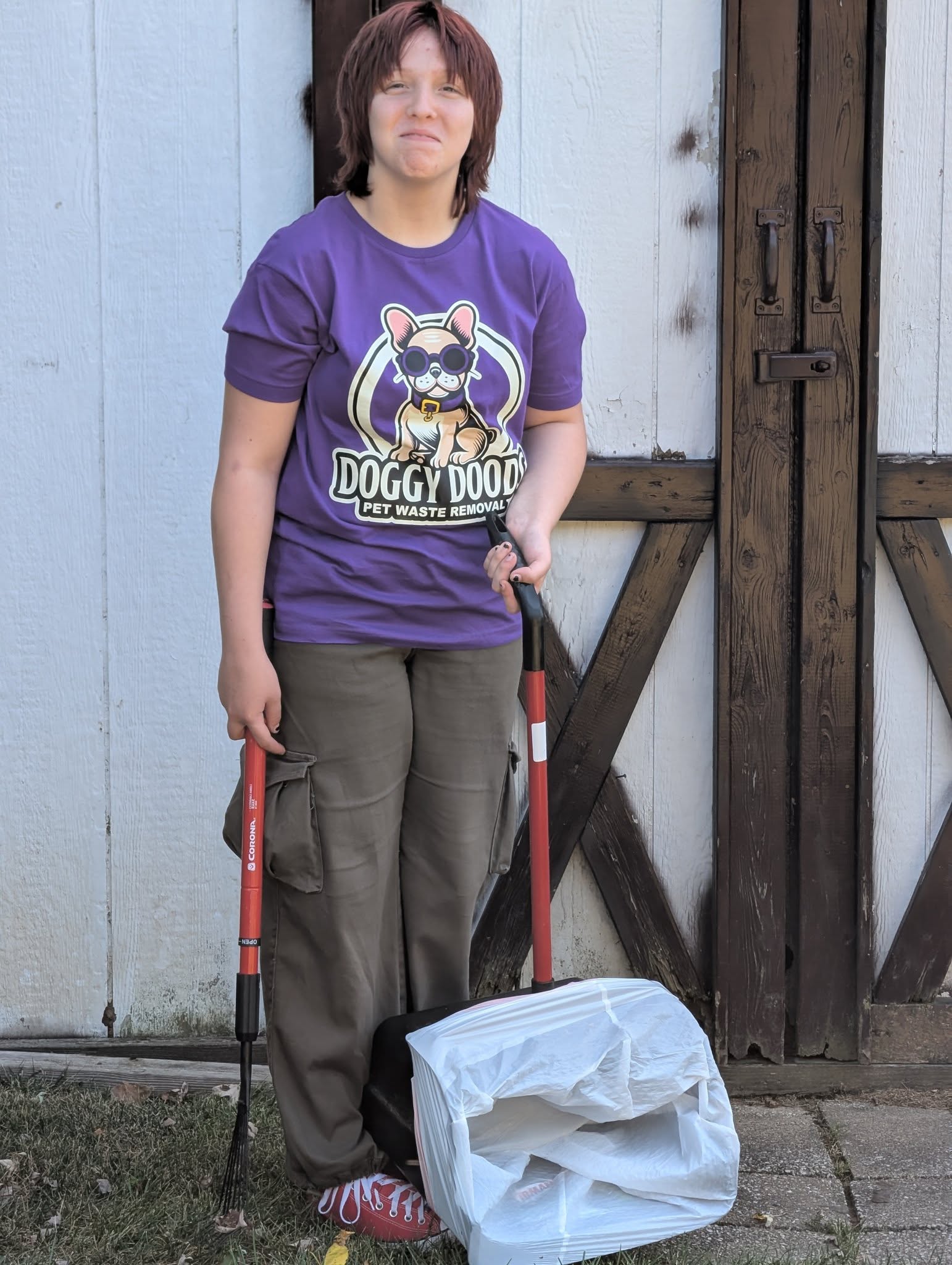 Doggy Doods family member helping clean a customer's yard during a pet waste removal visit in St. Charles County, Missouri.