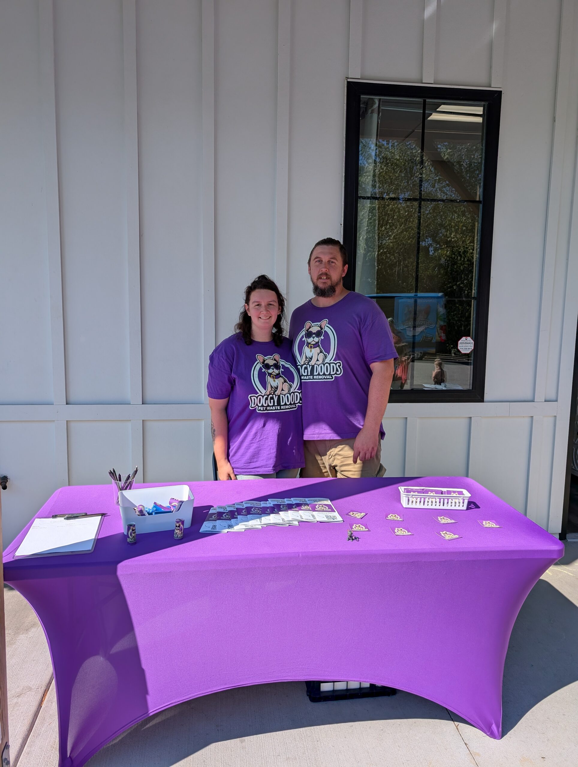 Doggy Doods owners Eugene and Harley at their purple event booth outside Cottleville Animal Hospital in Cottleville, Missouri.