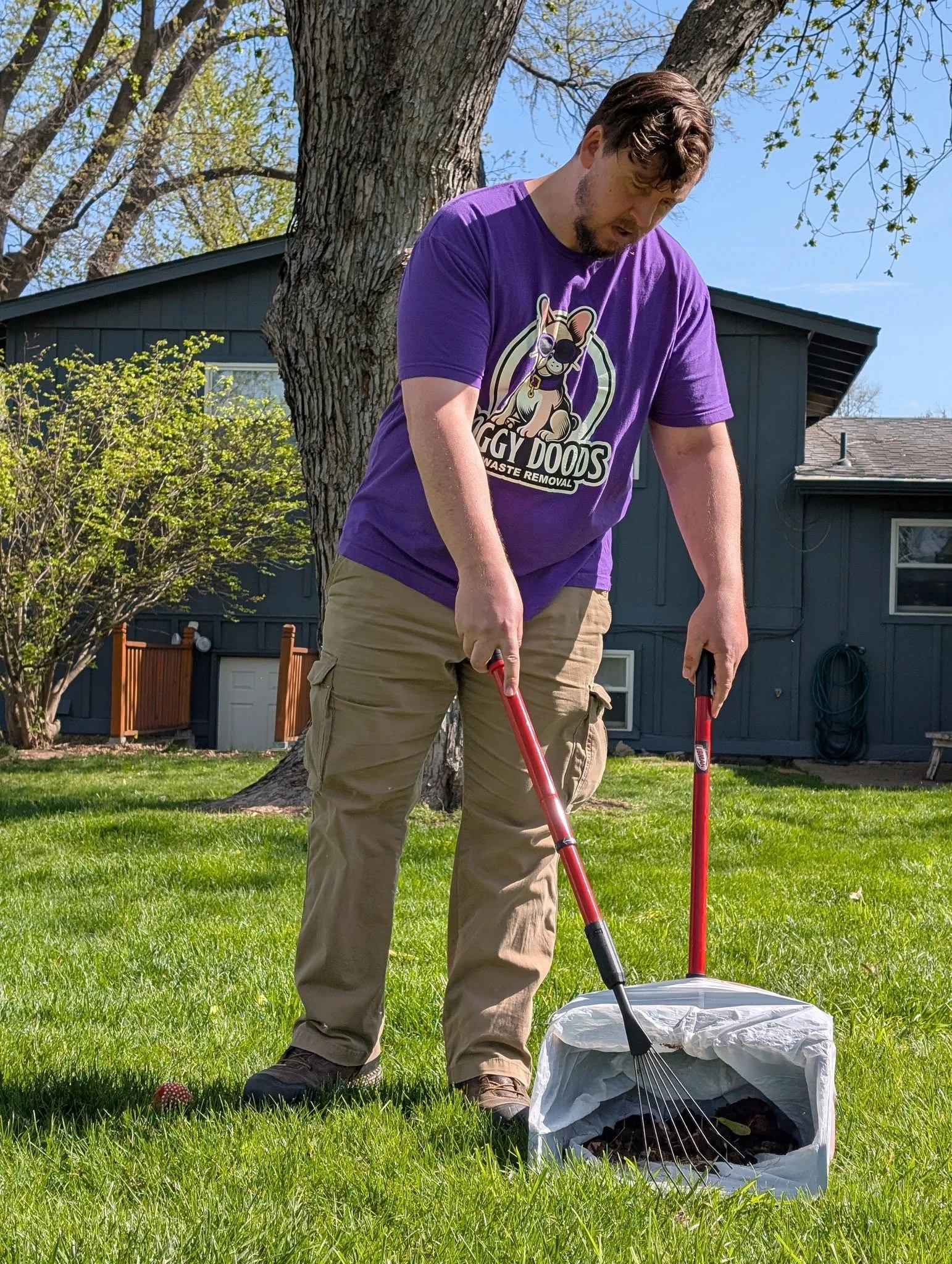 Doggy Doods owner cleaning a customer's backyard during routine pooper scooper service in St. Charles County.